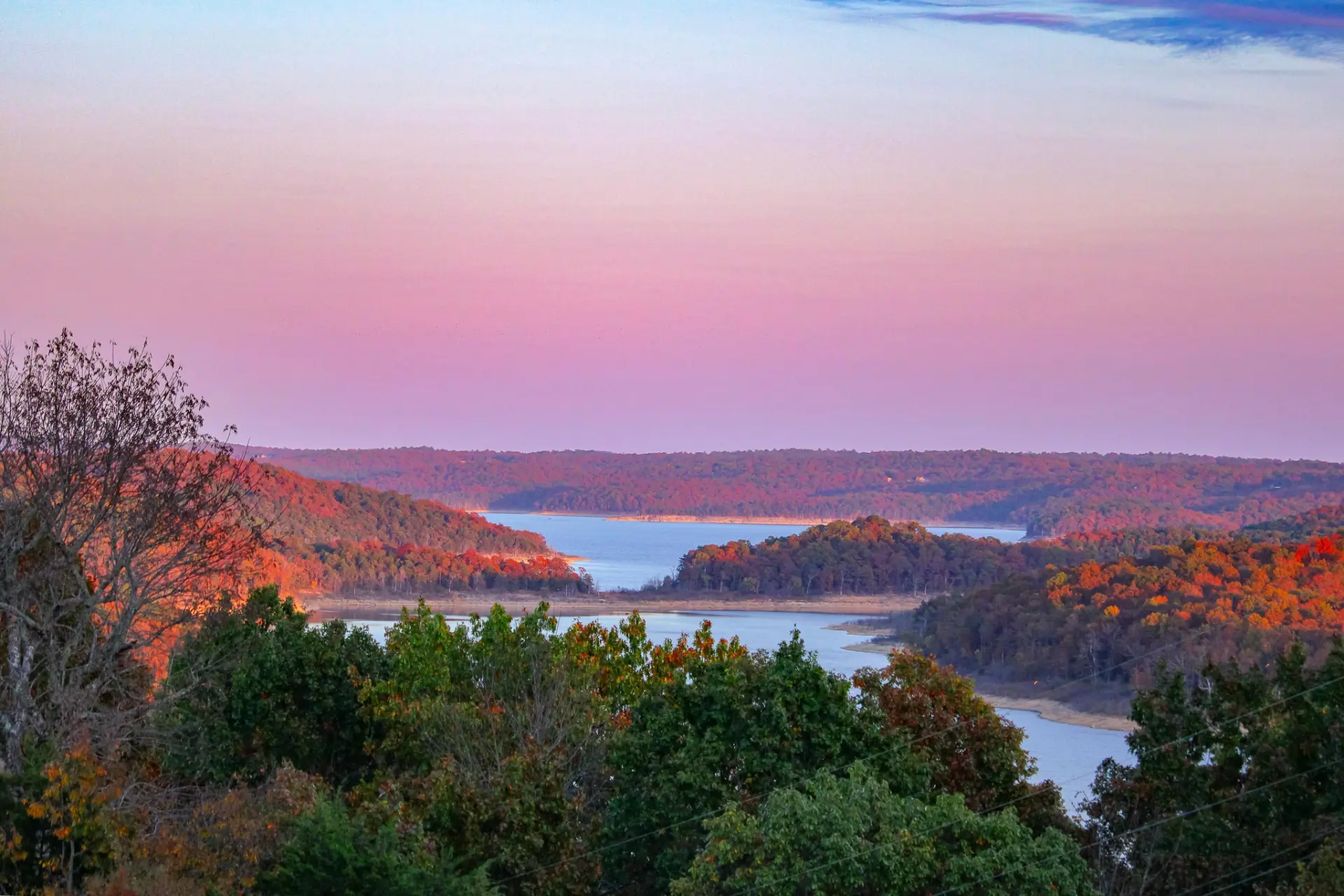 Vista de terreno natural na Flórida ao entardecer, com lago e vegetação